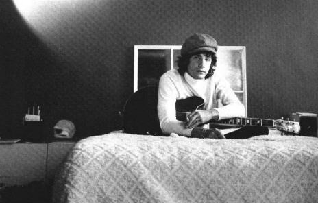 Young Cat sitting on his bed at his parents' house.